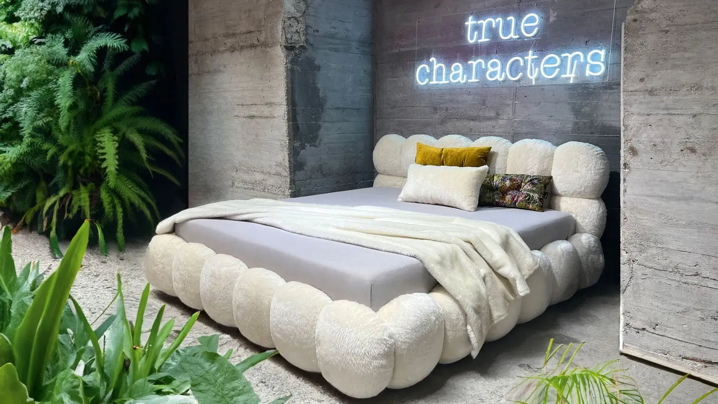 Luxury Balaao bed by BRETZ with unique round upholstered elements in a modern, greenery-filled bedroom setting