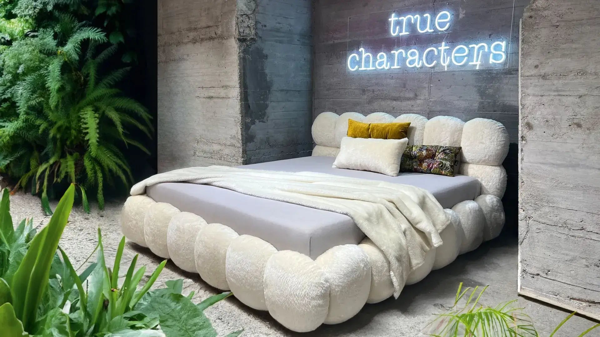Luxury Balaao bed by BRETZ with unique round upholstered elements in a modern, greenery-filled bedroom setting